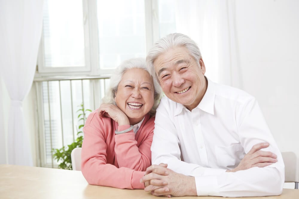 smiling asian couple with dentures